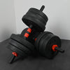 Pair of black dumbbells with red accents on a dark surface