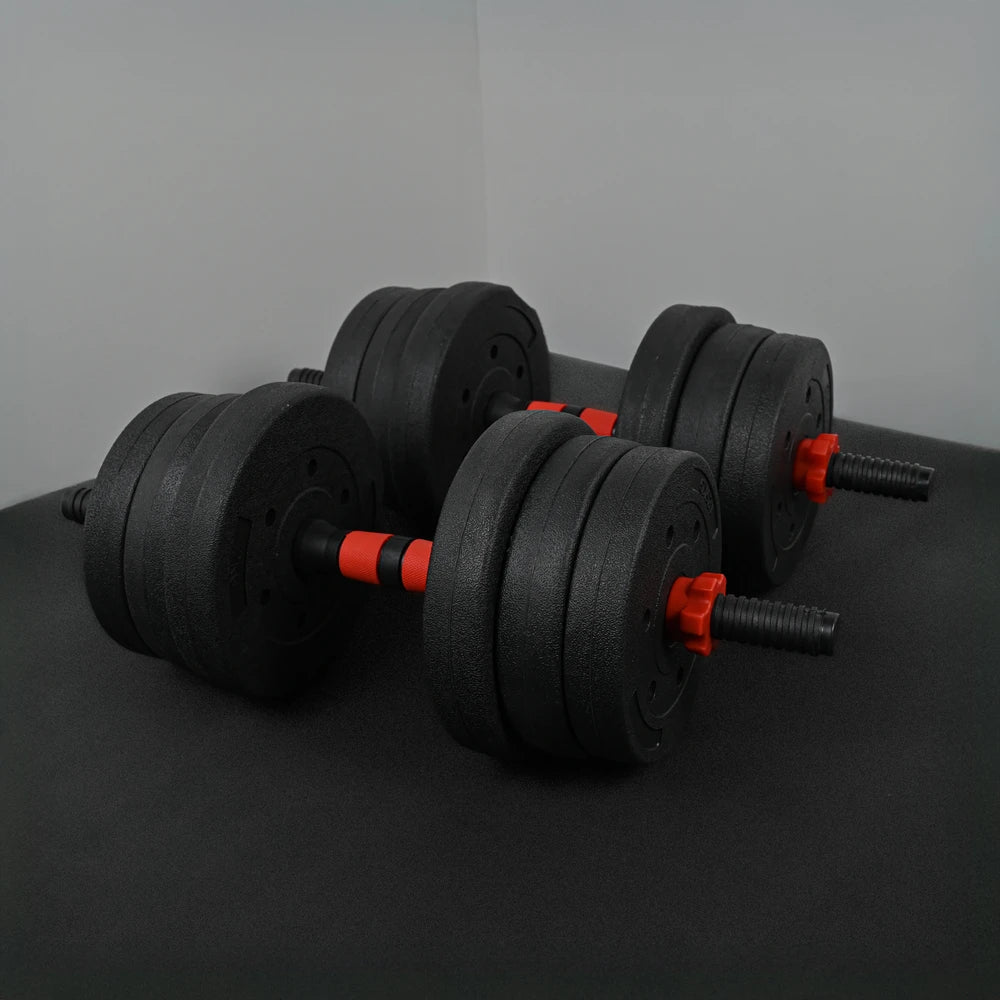Pair of black adjustable dumbbells with red accents on a dark surface.
