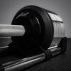 Close-up of a barbell with weight plates on a dark surface