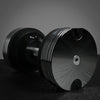 Pair of black dumbbells on a dark surface with a gray background