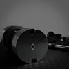 Black dumbbell on a textured surface with a dark background