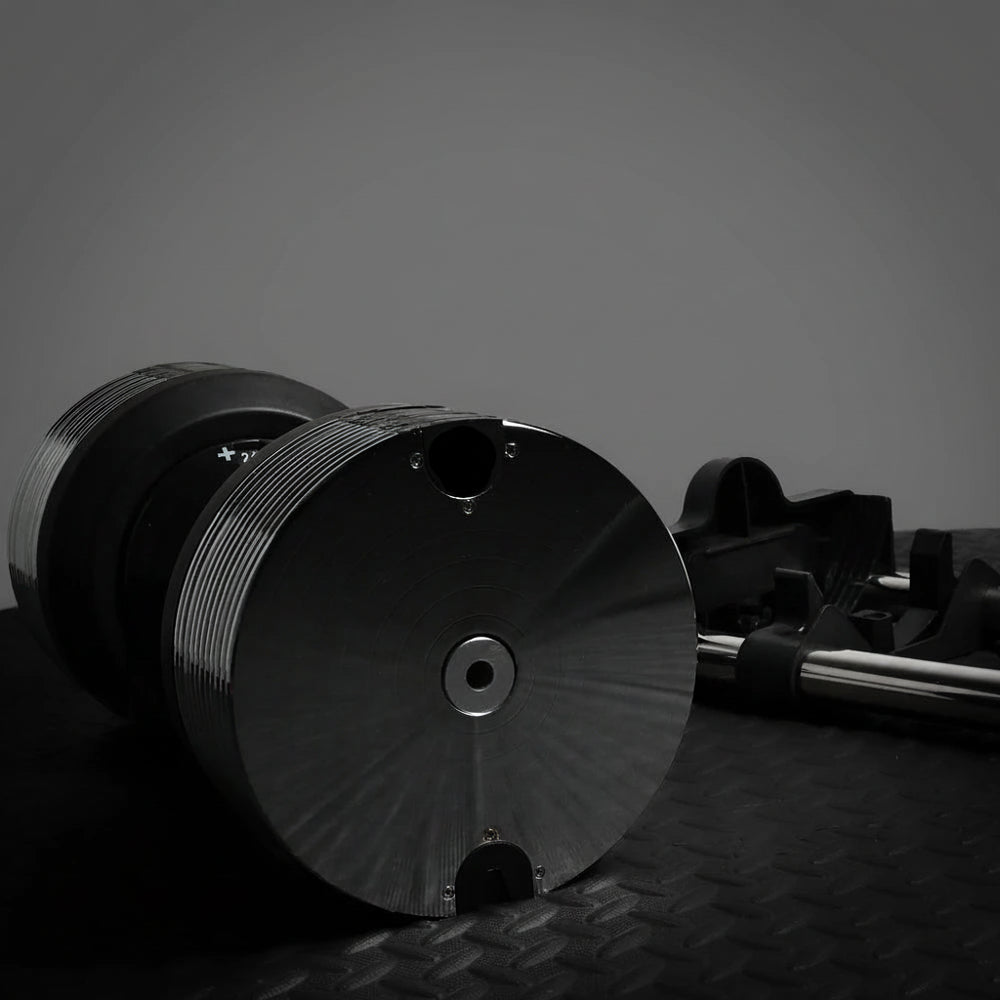 Black dumbbell on a textured surface with a dark background