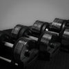 Set of black dumbbells on a dark surface with a neutral background