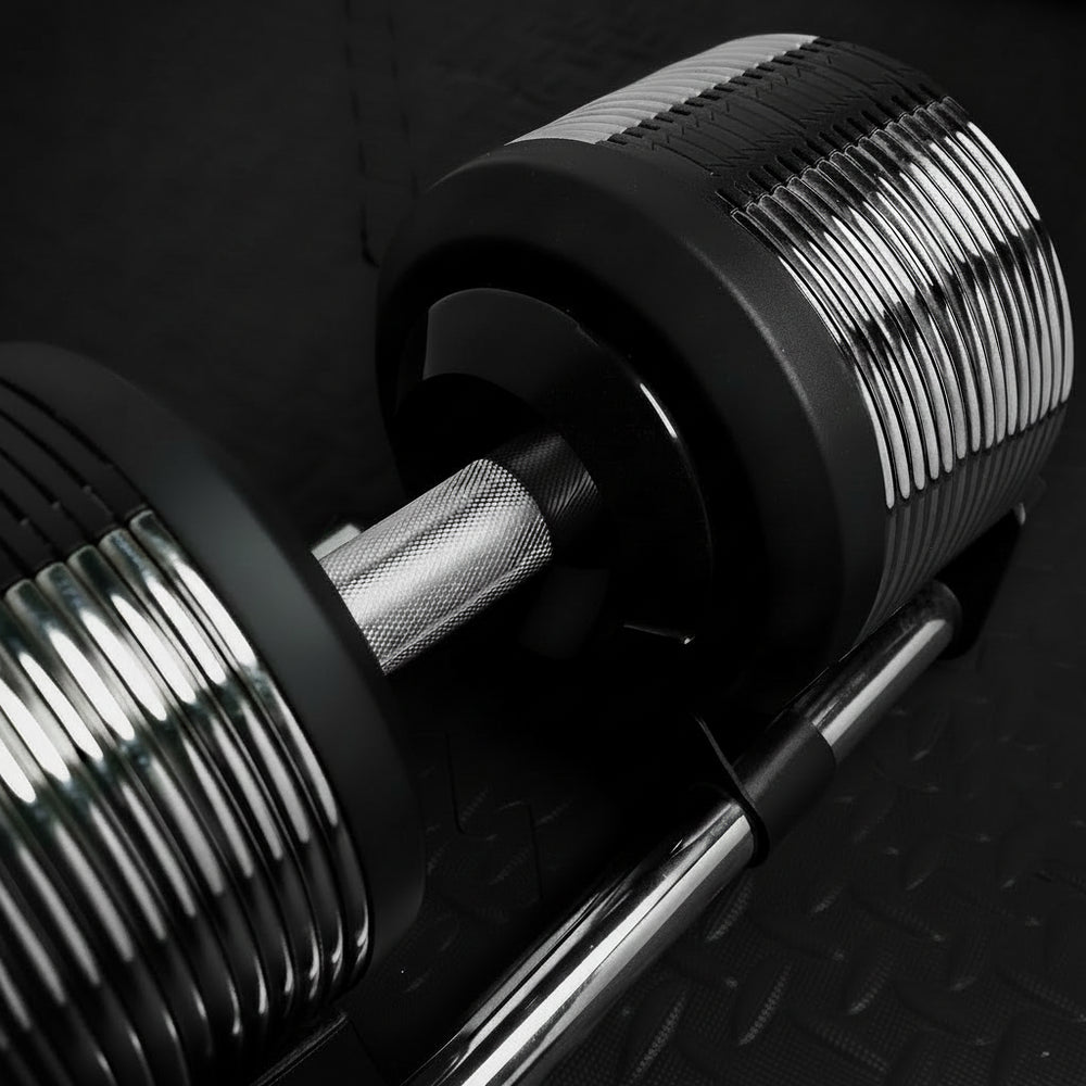 Close-up of a gym barbell with weight plates on a dark background