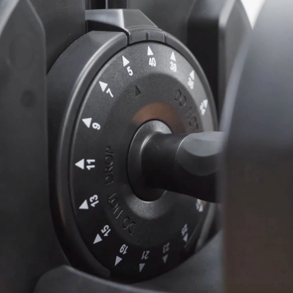 Close-up of a black knob with numerical markings on a dark background