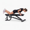 Woman exercising on a black adjustable weight bench against a white background