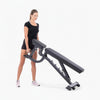 Woman using a black adjustable weight bench on a white background