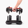 Person holding a pair of adjustable dumbbells with a white background