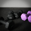 Pair of black and purple dumbbells on a dark surface