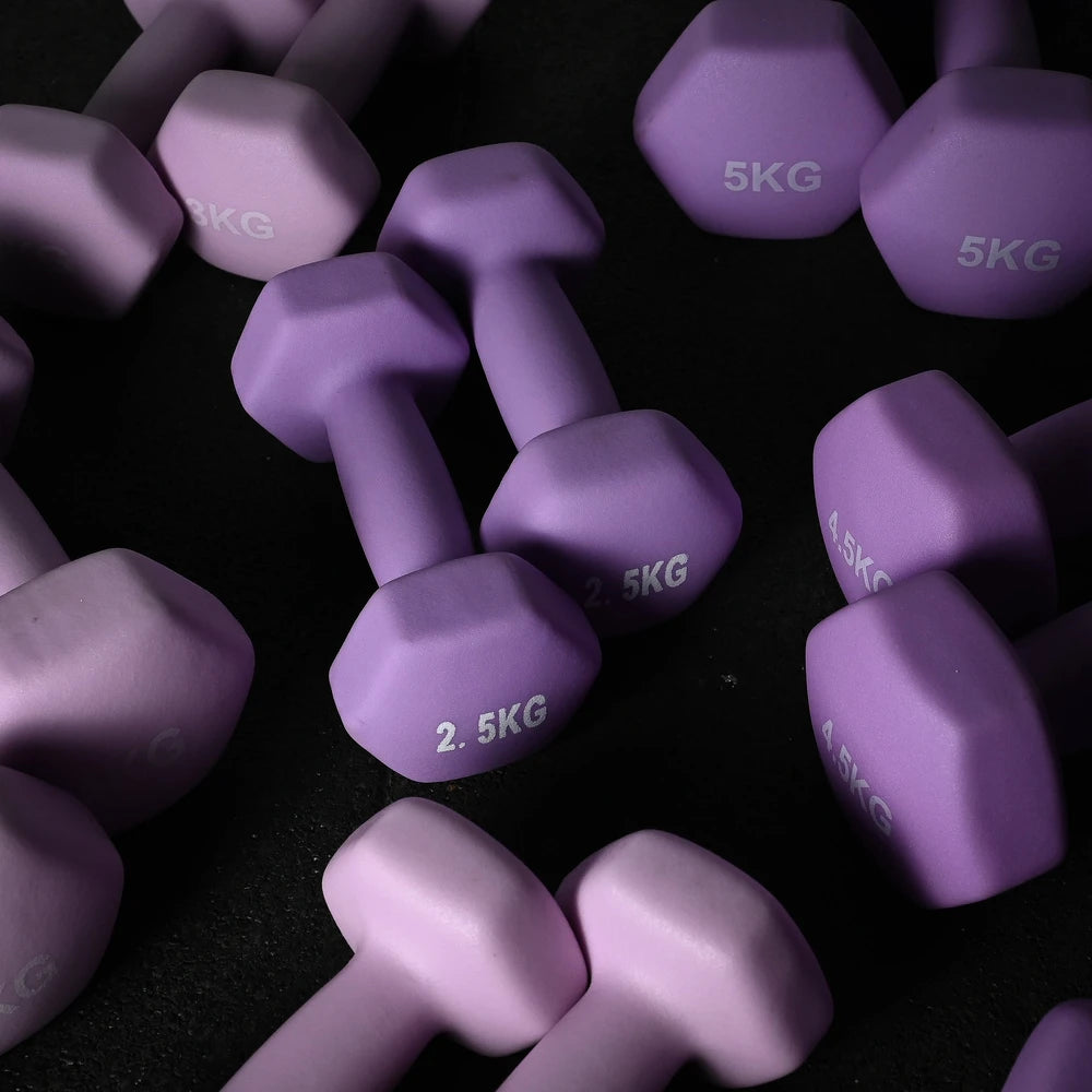 Purple dumbbells with weight markings on a dark surface