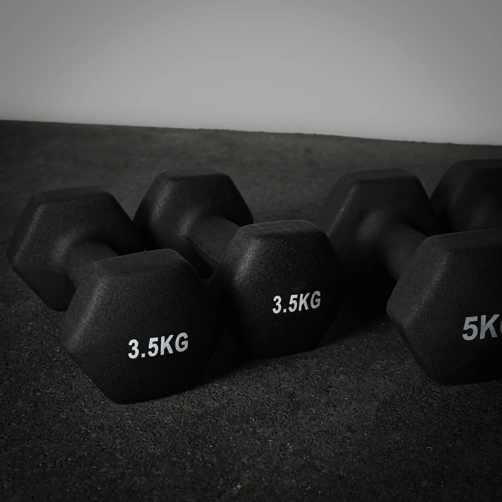 Pair of black dumbbells with weight markings on a dark surface