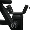 Close-up of a black exercise machine with a focus on the seat post and control knob.