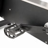 Close-up of exercise bike showing a black metal pedal and part of the silver flywheel against a white background.