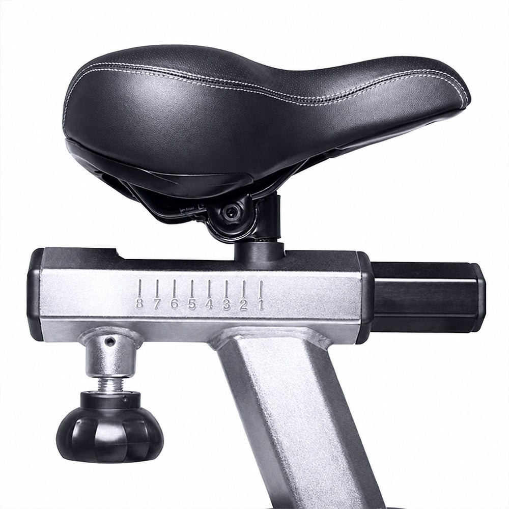Close-up of a bicycle saddle mounted on a silver and black indoor trainer frame