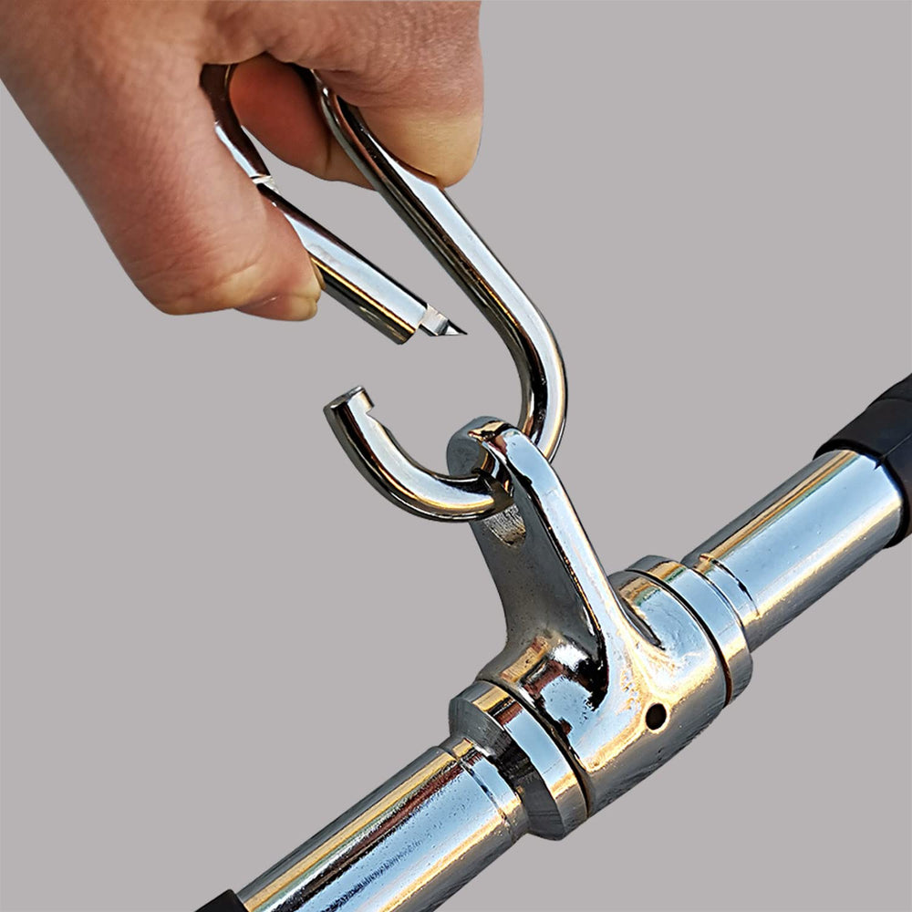 Hand holding a chrome metal tool with a gray background