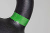 Close-up of a black object with a green band on a gray background