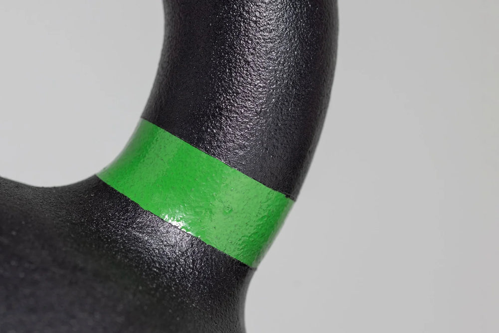 Close-up of a black object with a green band on a gray background