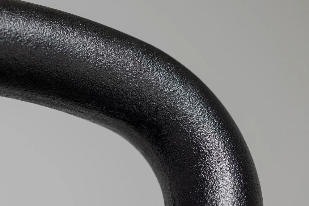 Close-up of a black metal handle on a gray background
