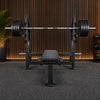 Gym flat weight bench with barbell on a white background