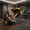 A leg extension gym machine with a black frame and seat, accented by a bright yellow upper support frame and silver metal barbell arms, shown on a white background.
