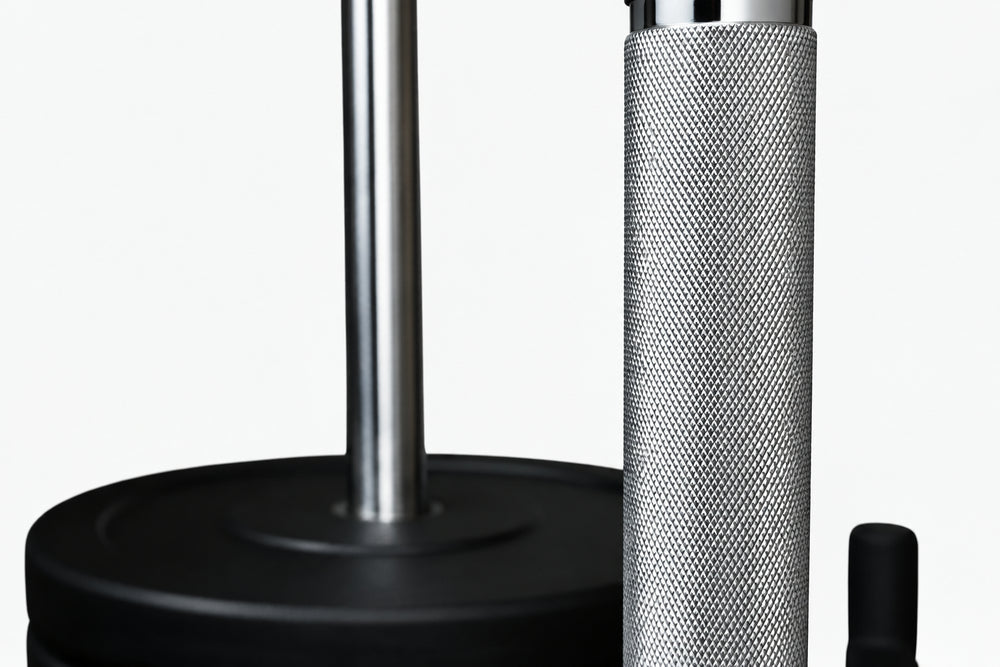 Close-up of weight plates loaded onto a power sled with textured anti slip grips on a white background