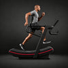 Man running on a treadmill against a dark background