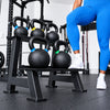 Person in light blue leggings and white sneakers standing next to a black kettlebell rack with kettlebells.
