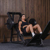 Woman exercising on a leg press machine in a gym setting