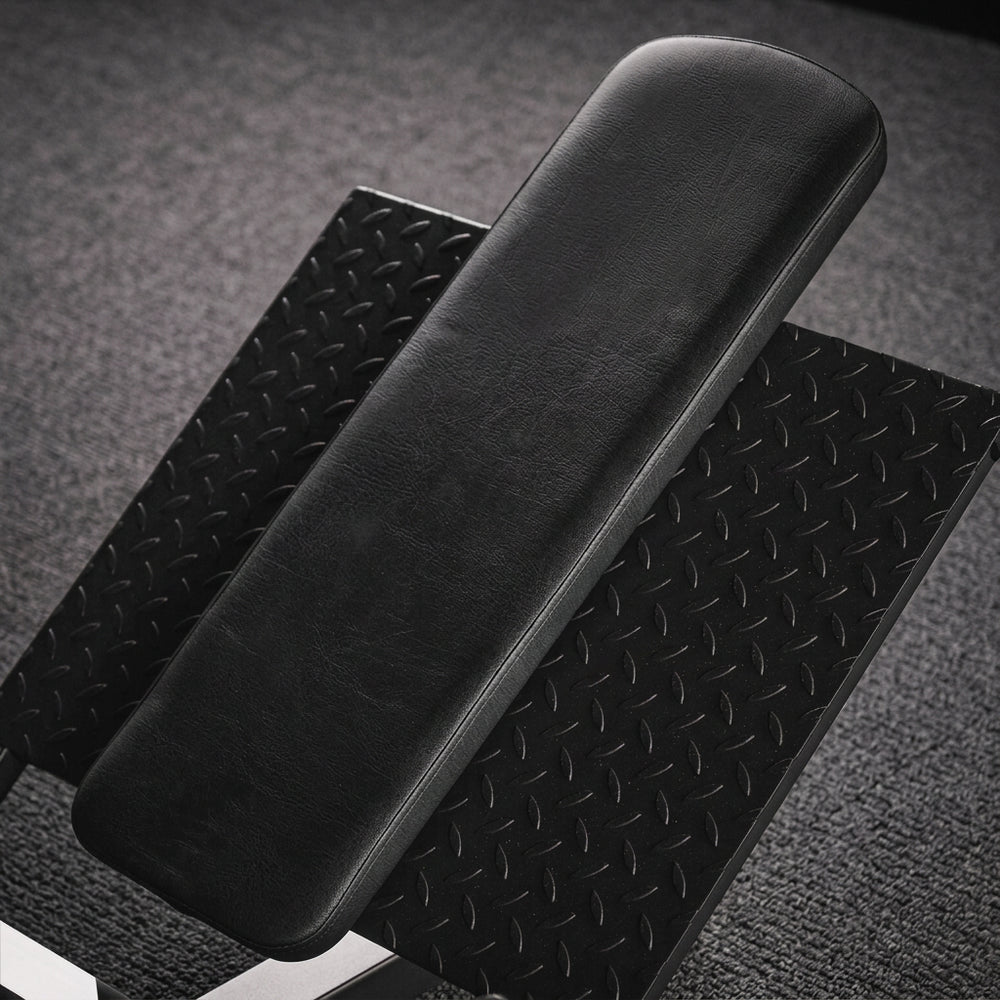 Black textured foot rest of a leg press