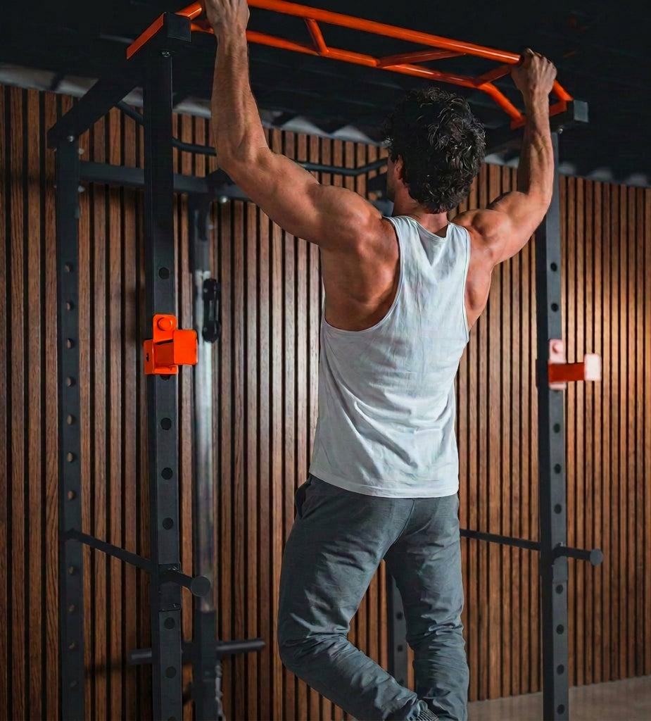 Person performing pull-ups on a pull-up bar in a gym setting.