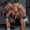 A shirtless man in a gym setting demonstrates a compact adjustable dumbbell