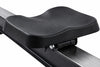 Close-up of a black padded exercise seat mounted on a dark metal frame, shown against a plain white background.