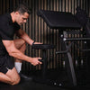 Man adjusting a gym machine in a dark setting