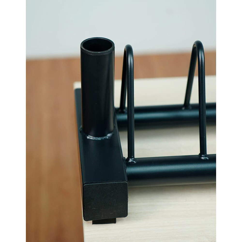 Close-up of a black metal weights organizer against a neutral background.