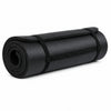 A rolled black yoga mat with a black strap shown on a white background