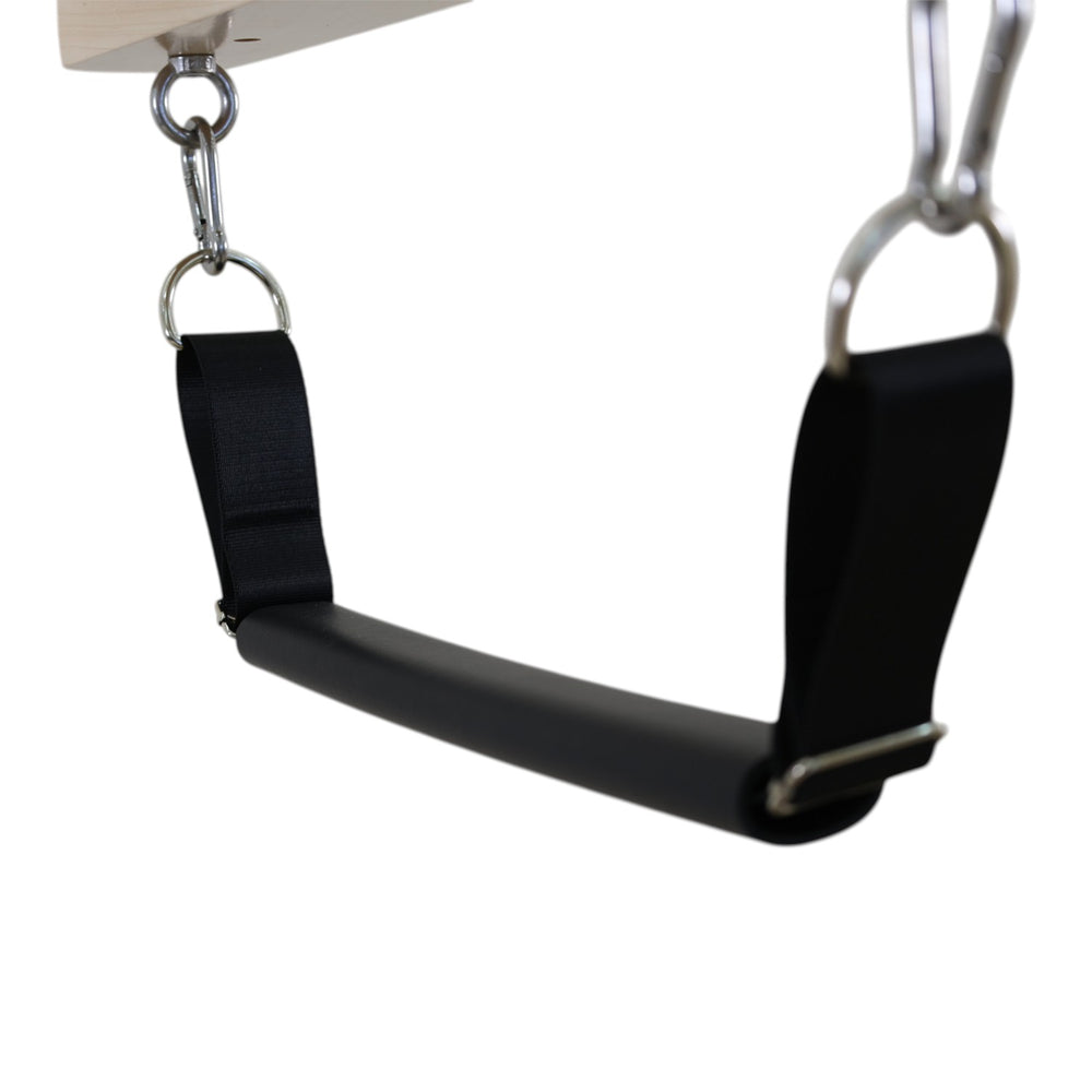 Close-up of the padded trapeze handle bar with adjustable straps on the Cadillac reformer
