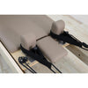 Gym Superstore wooden Pilates reformer carriage with taupe padded upholstery and black adjustable hand straps