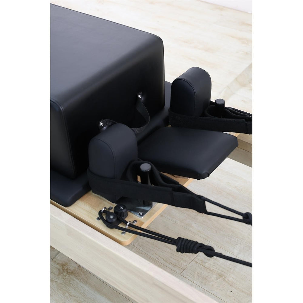 Gym Superstore professional wooden Pilates reformer carriage with black padded upholstery and adjustable straps