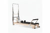 Pilates reformer tower in oak with black seats on a white background - Premium Pilates Reformer | Gym Superstore
