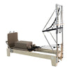 Gym Superstore professional wooden Pilates reformer with integrated tower attachment, beige padding, and springs.