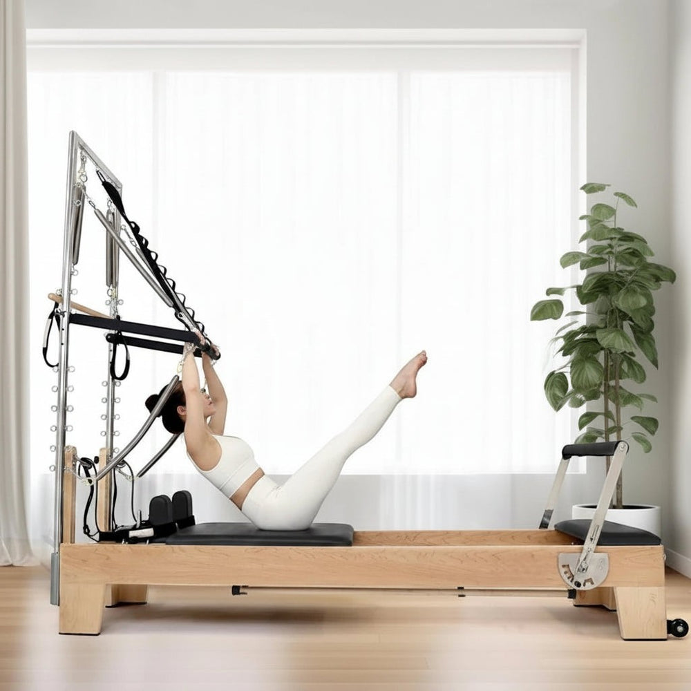 Woman using a pilates reformer tower machine in a home gym setting